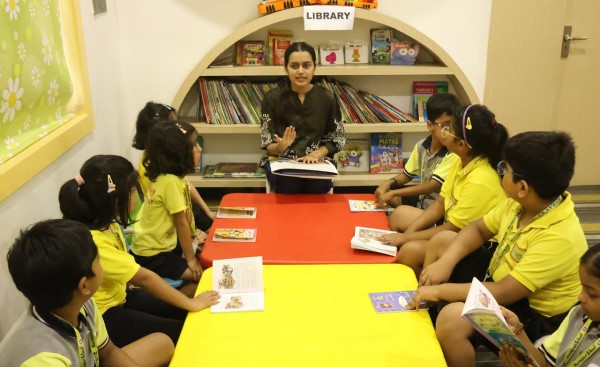Children exploring books and developing reading skills in the library at Crayons Montessori Play School Ranchi
